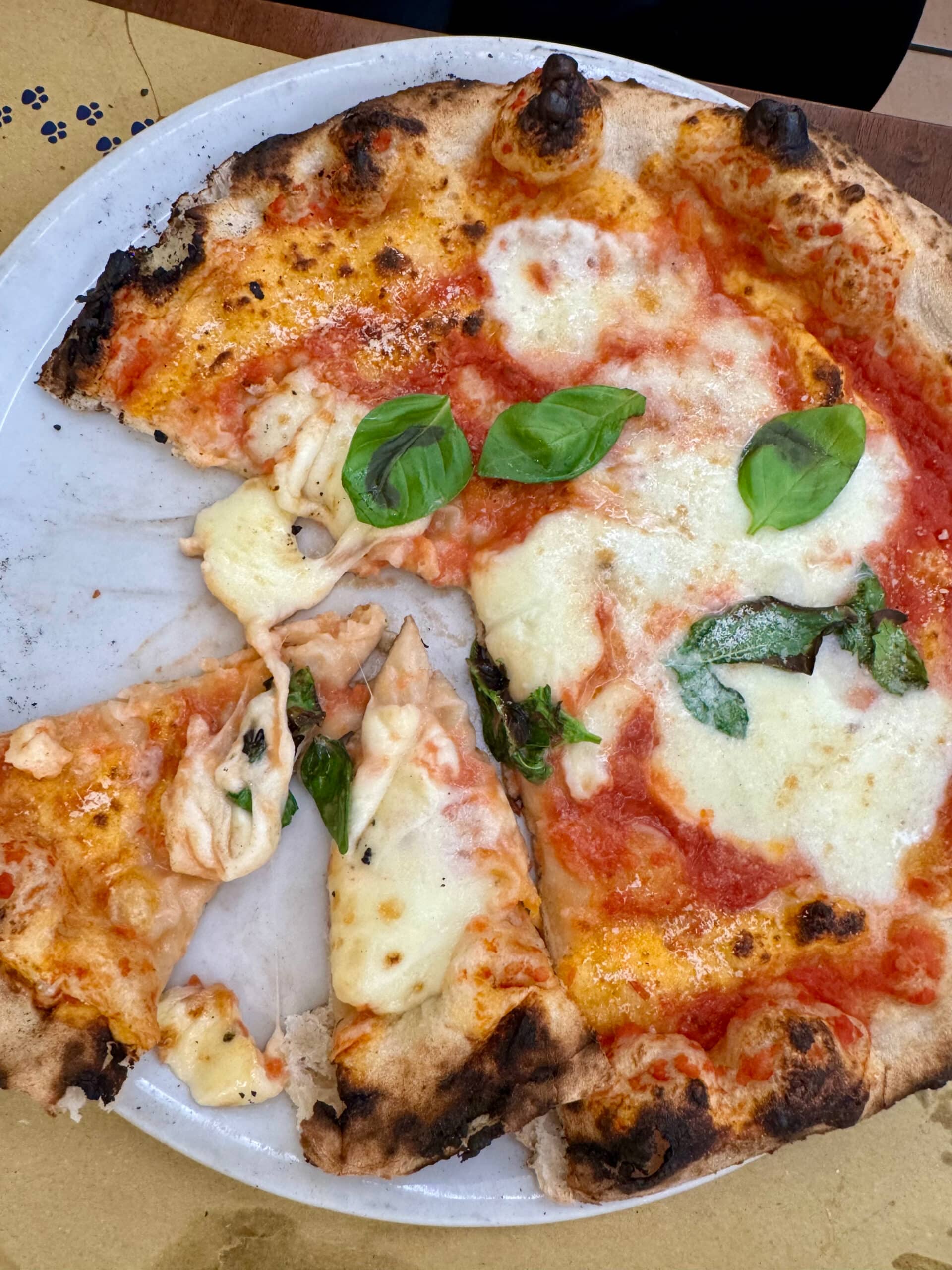 A traditional margherita pizza on a white platter.