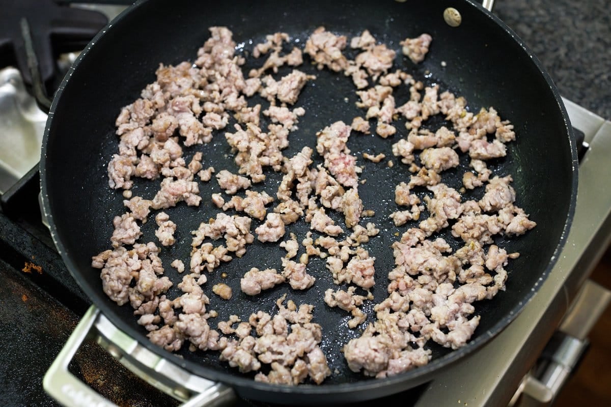 Cooking sausage in a skillet on the stove.