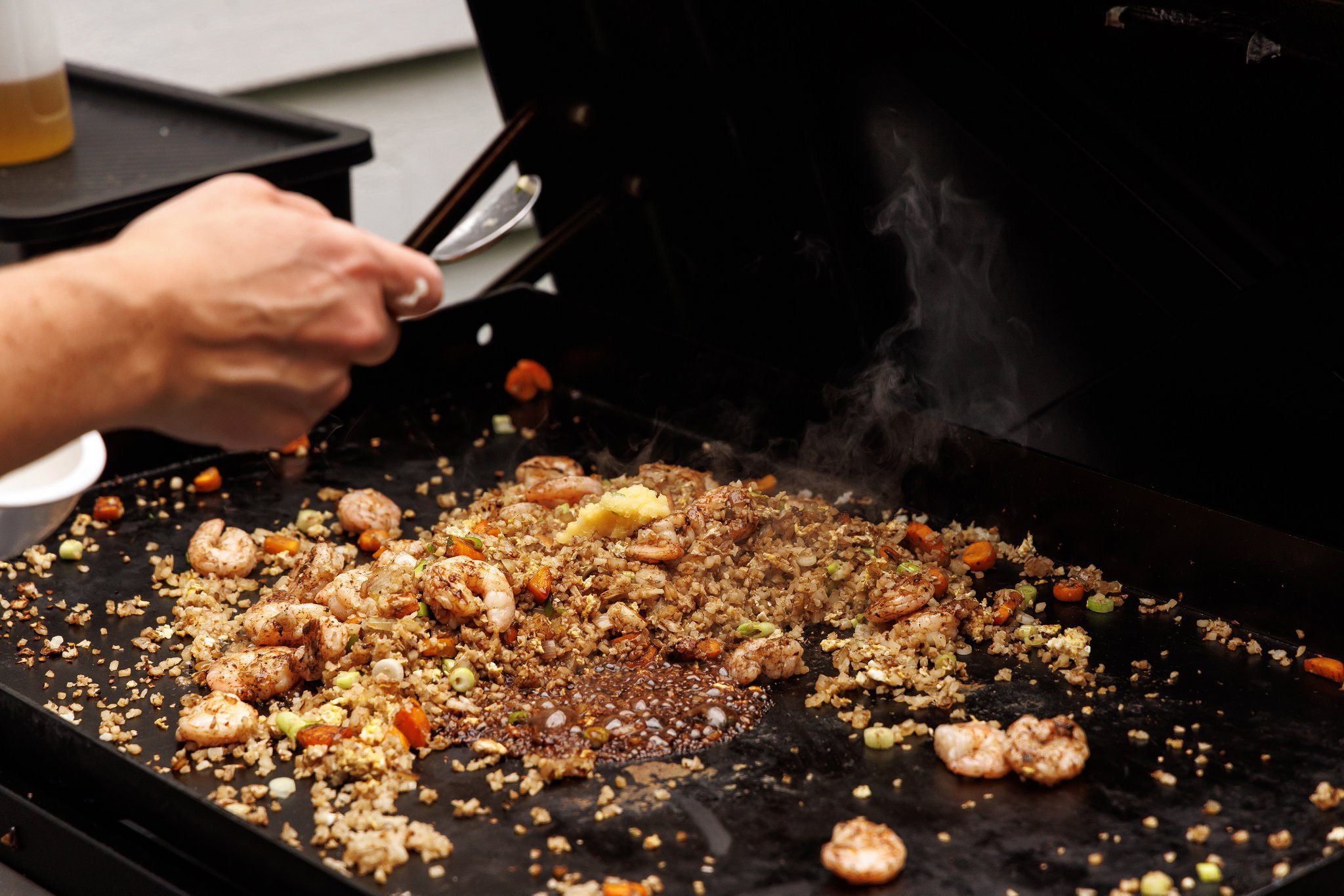 Cooked shrimp added to fried rice with soy sauce.