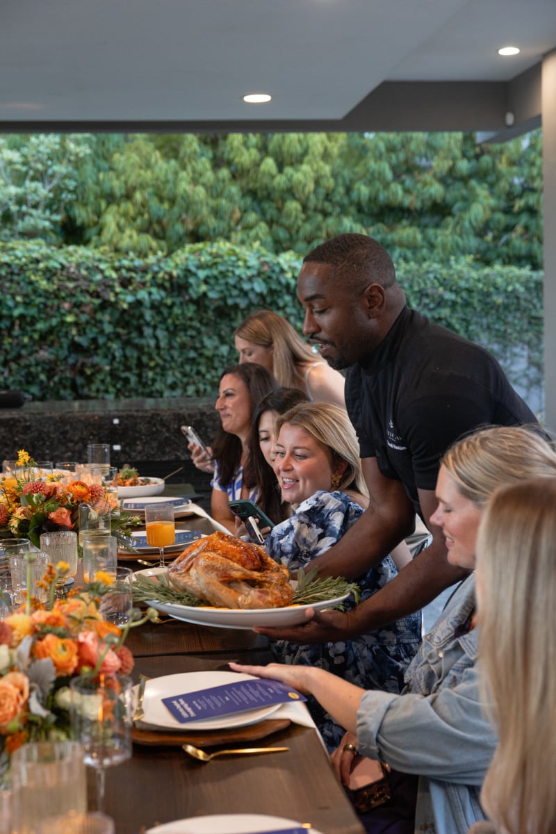 Serving cooked freezer to oven turkey on a platter to a table full of friends.