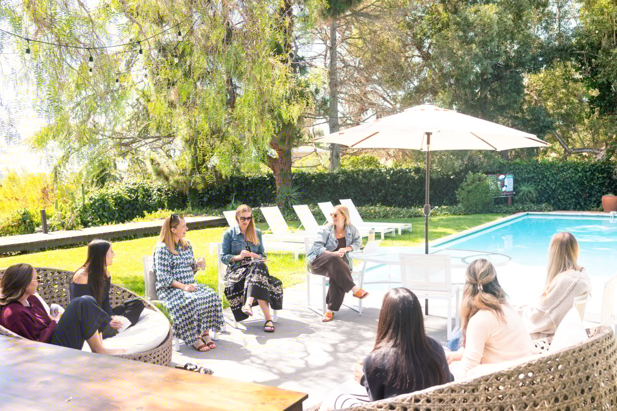 Attendees of the Fresh Air Retreat sitting in a circle next to the pool.