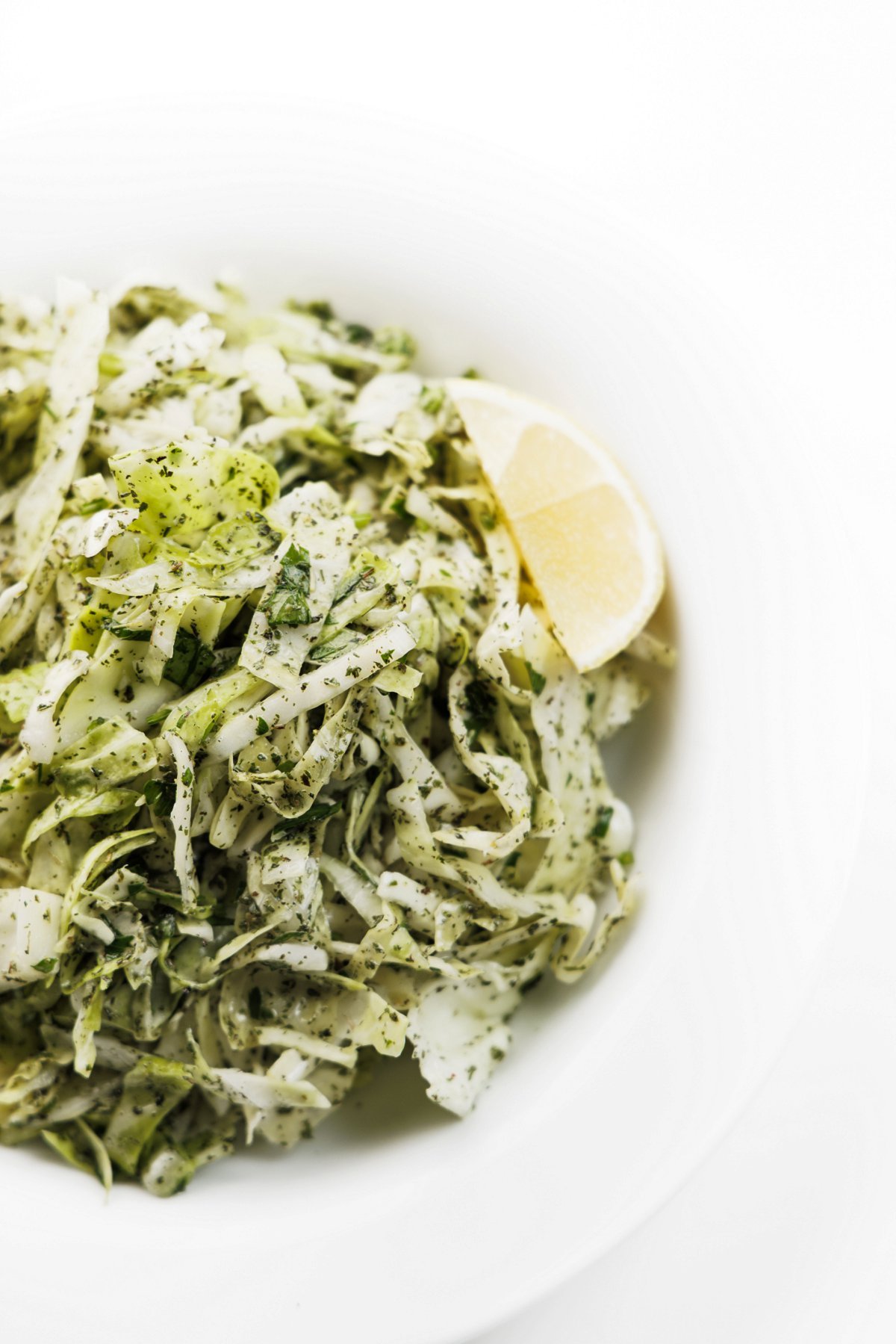 Lebanese cabbage salad topped with dried mint and a lemon wedge.