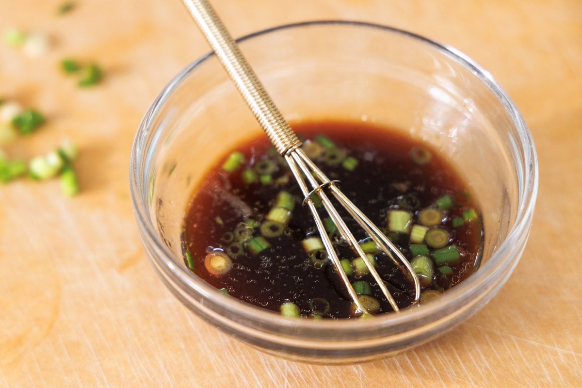 Whisking soy dipping sauce in small bowl.